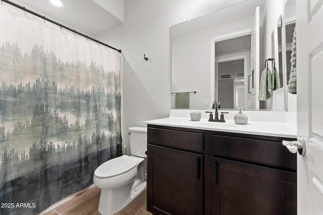 bathroom with vanity, walk in shower, and toilet