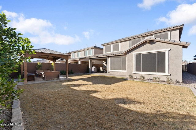 rear view of property featuring a gazebo, a lawn, and a patio area