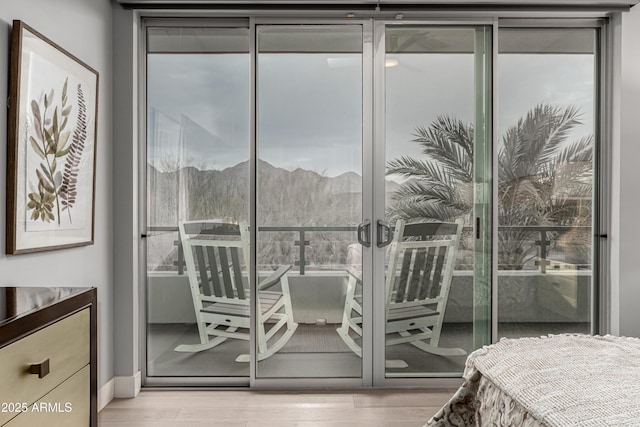 bedroom with a mountain view and wood finished floors