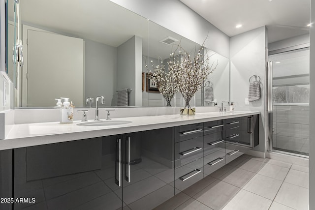 bathroom with a sink, visible vents, double vanity, and tile patterned flooring