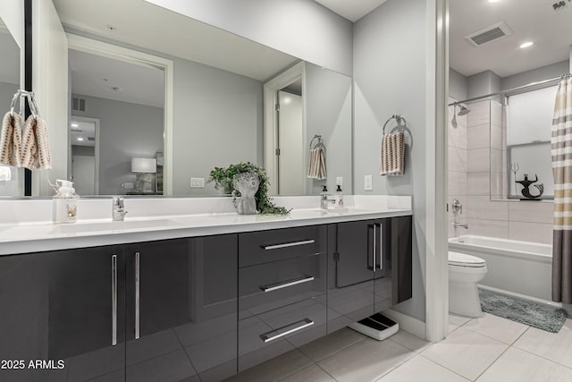 bathroom featuring visible vents, shower / bath combination with curtain, toilet, and a sink