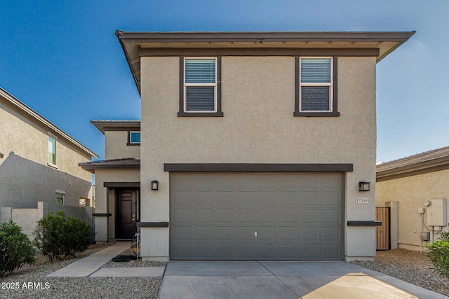 view of front of house featuring a garage, concrete driveway, fence, and stucco siding