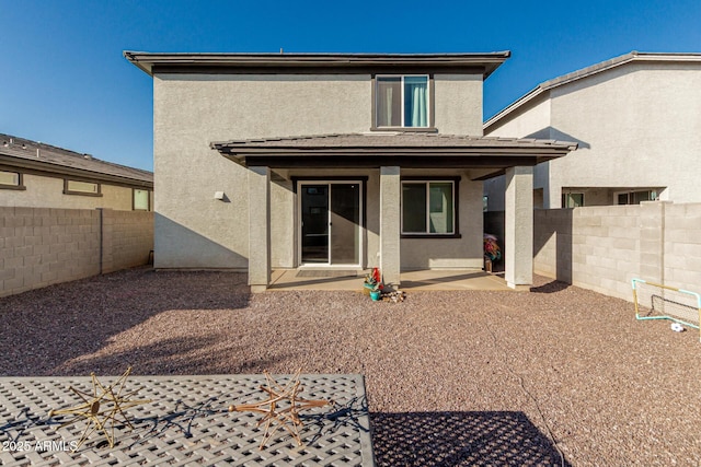 rear view of house featuring a patio area, a fenced backyard, and stucco siding