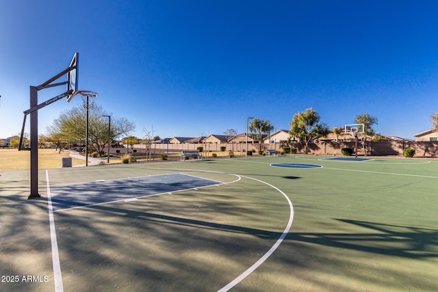 view of basketball court featuring a residential view, community basketball court, and fence