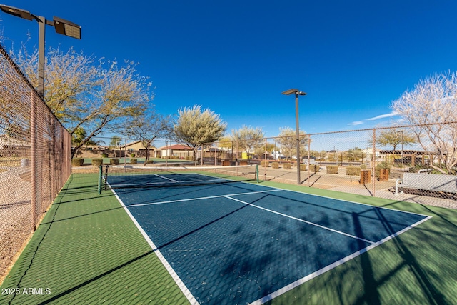 view of tennis court featuring fence