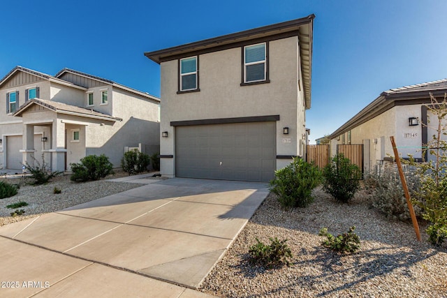 view of front of property featuring a garage, driveway, fence, and stucco siding