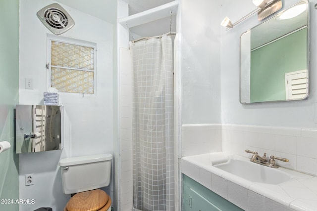 bathroom featuring vanity, toilet, and curtained shower