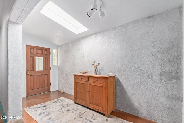 foyer featuring vaulted ceiling with skylight