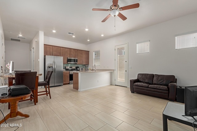 10502 W Bronco Trl, Peoria, AZ 85383 - kitchen featuring stainless steel appliances, open floor plan, light countertops, a peninsula, and a ceiling fan