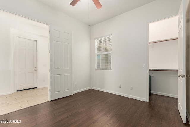 10502 W Bronco Trl, Peoria, AZ 85383 - unfurnished bedroom featuring wood finished floors, a walk in closet, baseboards, and a closet