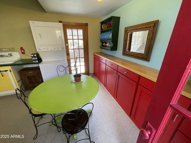 dining room featuring stacked washer / dryer and sink