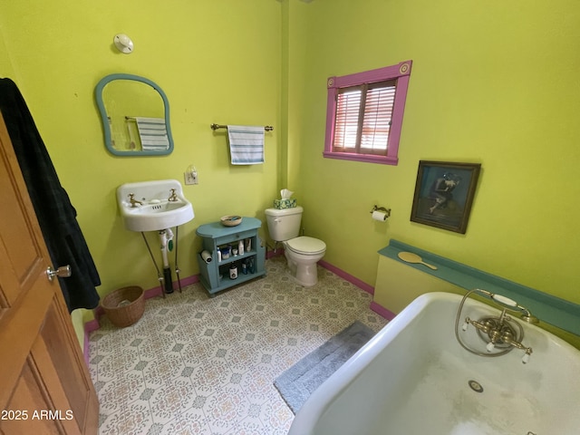 bathroom with a tub, tile patterned floors, and toilet