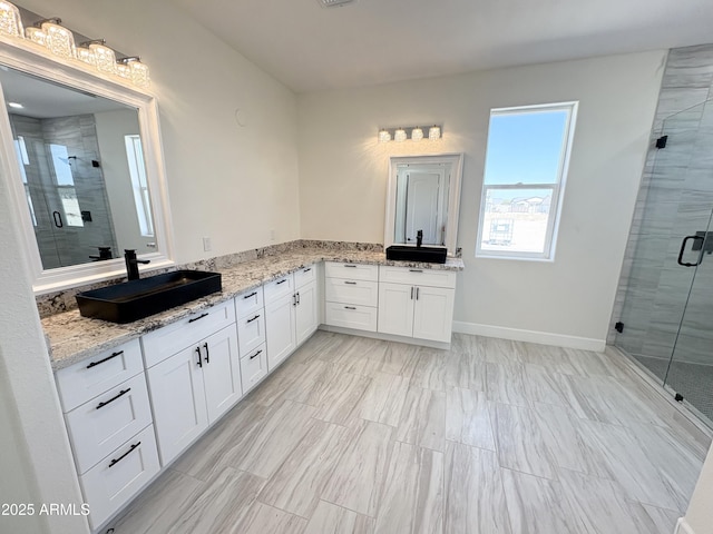 bathroom featuring a shower stall, vanity, and baseboards