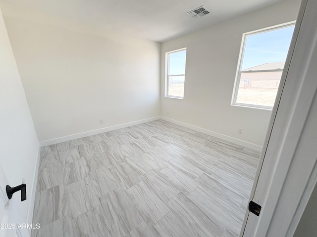 spare room with visible vents and baseboards