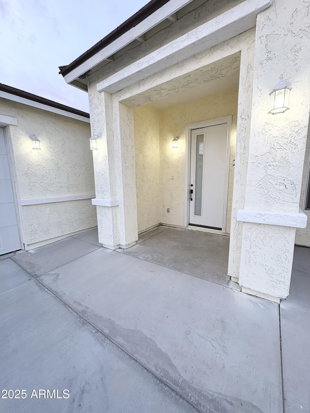 view of exterior entry featuring stucco siding