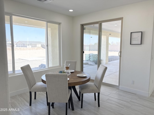 dining space featuring baseboards, a wealth of natural light, and recessed lighting