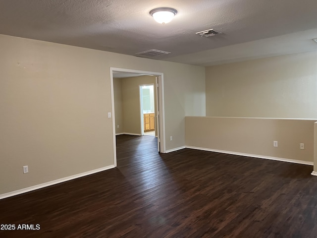 spare room featuring dark wood finished floors and baseboards