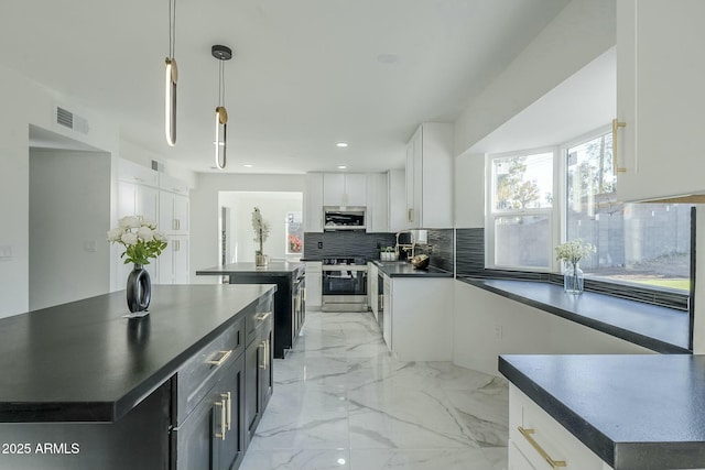 kitchen with tasteful backsplash, white cabinetry, hanging light fixtures, a large island, and stainless steel appliances