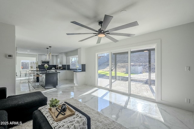 living room featuring plenty of natural light and ceiling fan