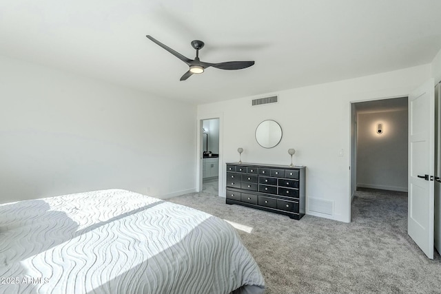 bedroom with ceiling fan, ensuite bath, and light carpet