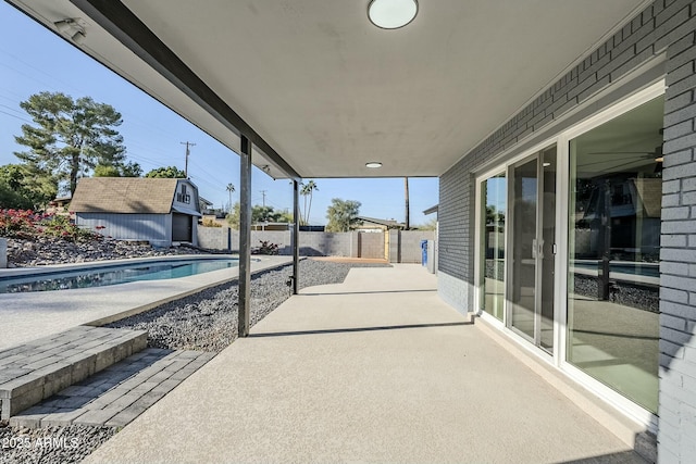 view of patio / terrace featuring a fenced in pool and an outbuilding