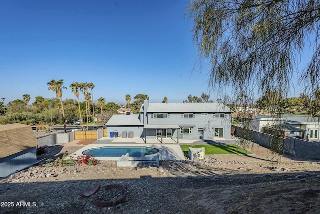 back of property with a fenced in pool and a patio