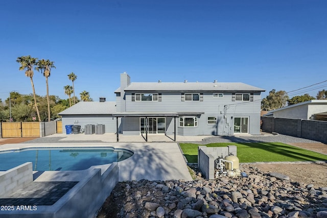 back of property featuring a fenced in pool, a patio, and central air condition unit