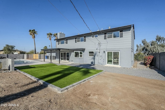 rear view of property featuring a lawn and a patio