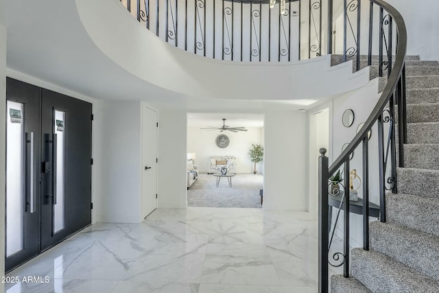 entryway with ceiling fan and a high ceiling