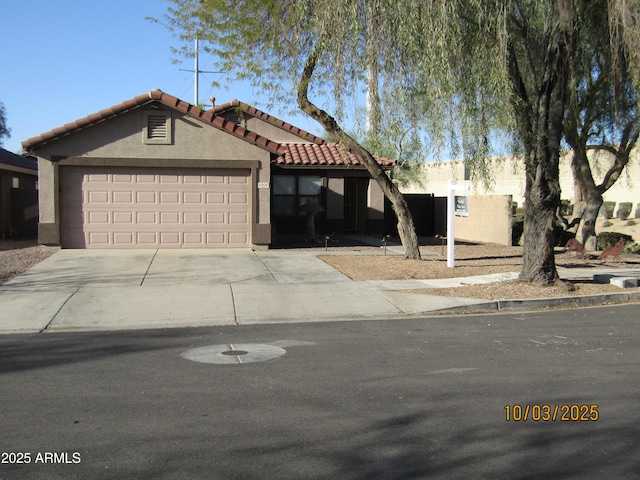 view of front of home featuring a tile roof, an attached garage, driveway, and stucco siding