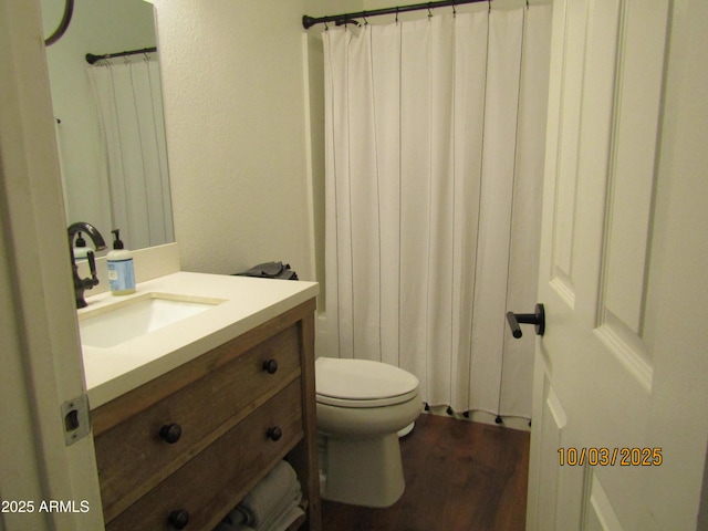 bathroom with toilet, vanity, a shower with curtain, and wood finished floors