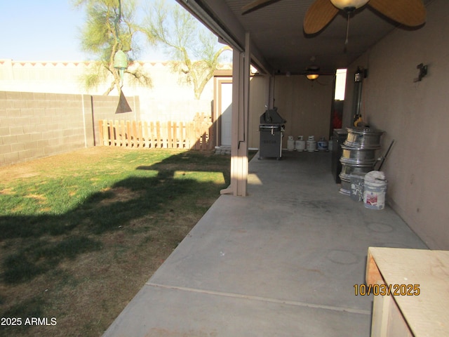 view of patio / terrace with area for grilling, fence, and ceiling fan