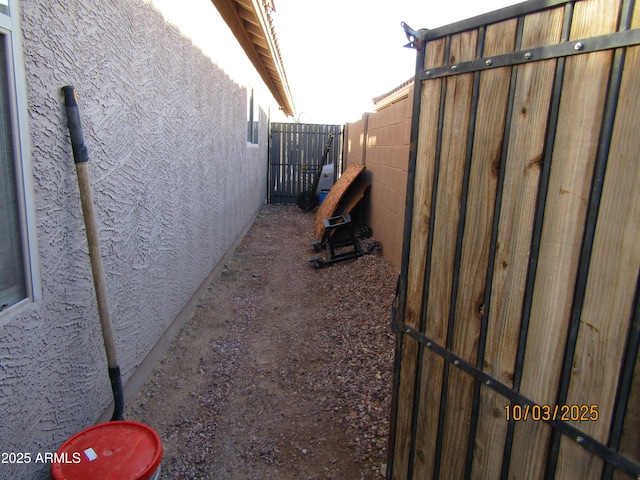 view of home's exterior with stucco siding and fence