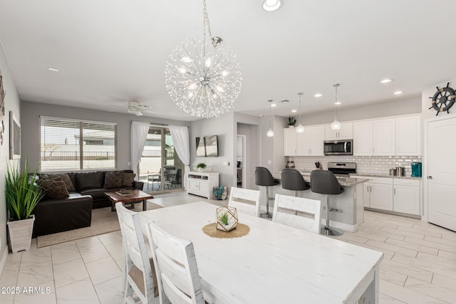 dining space featuring recessed lighting, ceiling fan with notable chandelier, and marble finish floor
