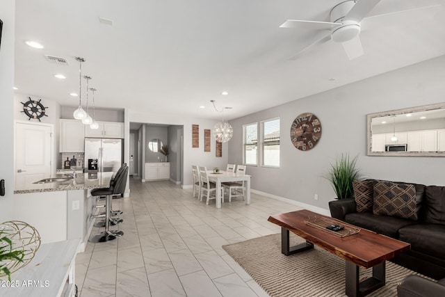 living room featuring visible vents, recessed lighting, ceiling fan with notable chandelier, and marble finish floor