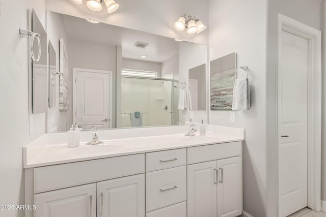 full bathroom with a sink, visible vents, a stall shower, and double vanity