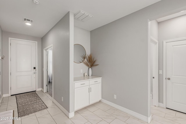 foyer entrance with visible vents, baseboards, and marble finish floor