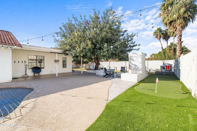 view of yard with a fenced in pool and a patio