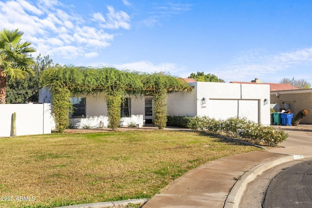 adobe home with a front yard and a garage