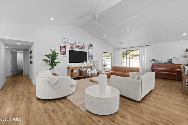 living room with ceiling fan, light hardwood / wood-style floors, and lofted ceiling