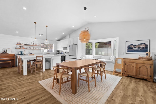 dining space featuring light hardwood / wood-style floors and vaulted ceiling