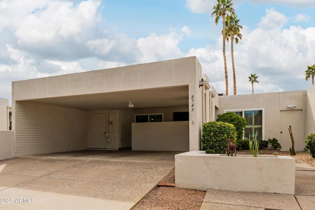 pueblo revival-style home featuring a carport and a garage