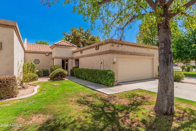 mediterranean / spanish-style house featuring a garage and a front yard