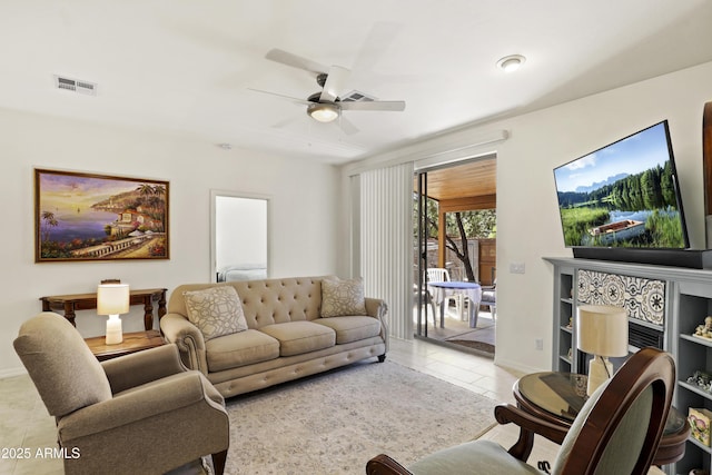 living area with a ceiling fan, baseboards, visible vents, and tile patterned flooring