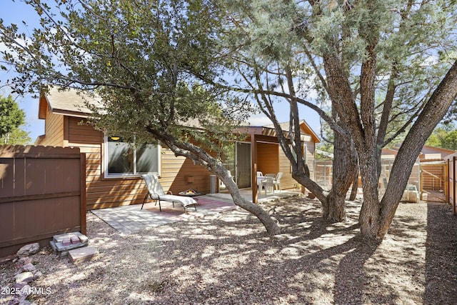 rear view of house with a patio and a fenced backyard