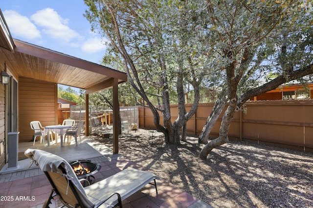 view of patio featuring a fenced backyard and a fire pit