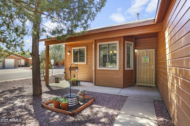 view of exterior entry with a patio