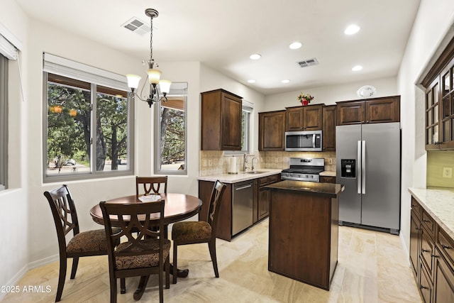 kitchen featuring visible vents, a sink, tasteful backsplash, and stainless steel appliances