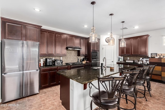 19889 W Montecito Ave, Litchfield Park, AZ 85340 - kitchen featuring appliances with stainless steel finishes, a sink, tasteful backsplash, a breakfast bar, and recessed lighting