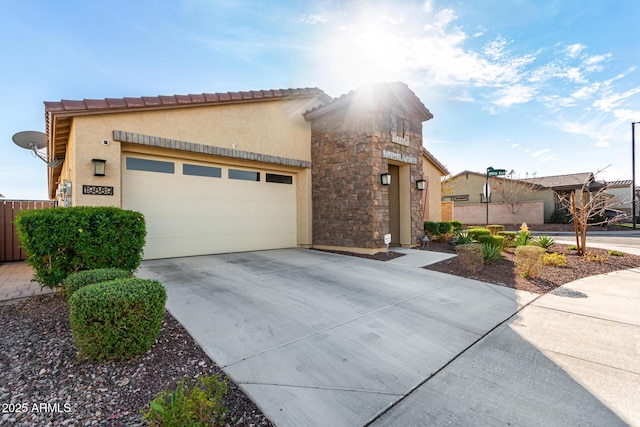 view of front of home featuring concrete driveway, stone siding, an attached garage, and stucco siding